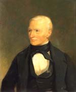 White man with short white hair wearing black coat, vest, and cravat with white shirt looks over his right shoulder.