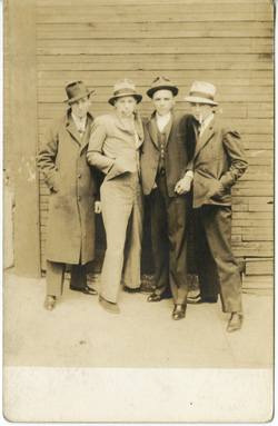 John Frank Keith, Two men and two boys in front of factory window, gelatin silver print on postcard mount, Philadelphia: ca. 1917.