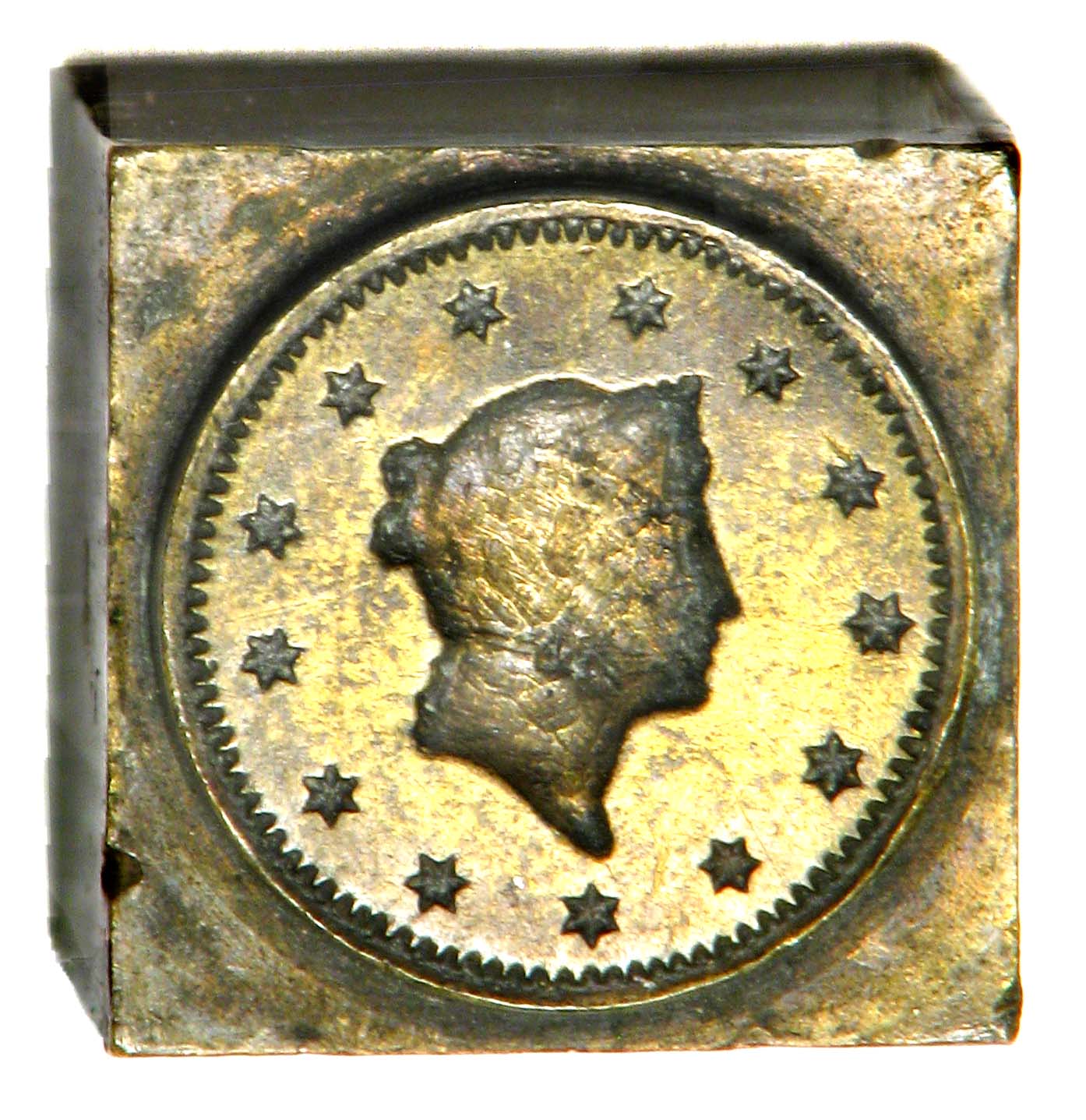 Brass die impressed with a woman's profile encircled by thirteen stars.