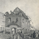 Men throw building materials off the top of a partially demolished structure standing among rubble. Pedestrains observe the activity from the sidewalk